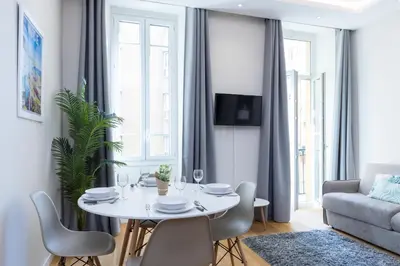 a living room with a table and chairs and a couch at Brand New 1 Bdr Place du Pin in Nice