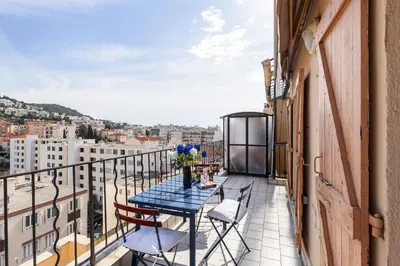 a table and chairs on a balcony with a view at Extraordinary View on Port and Castle Hill - 1 Bdr & Parking in Nice