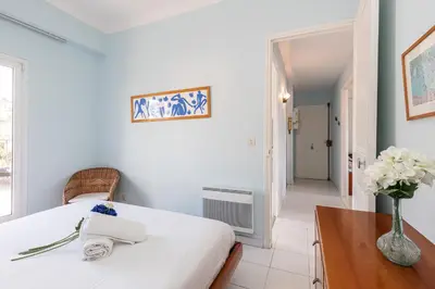 a bedroom with a bed and a table and a vase of flowers at Extraordinary View on Port and Castle Hill - 1 Bdr & Parking in Nice