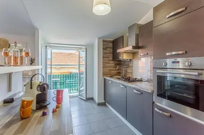 a kitchen with stainless steel appliances and a large window at Maison Bianchi - Saint Siagre in Nice