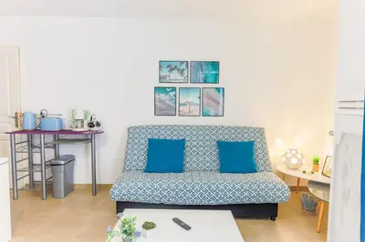 a living room with a couch with blue pillows at PALAIS OTHELLO in Nice