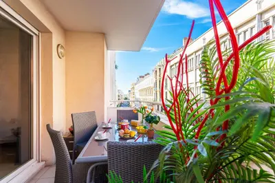 a patio with a table and chairs on a balcony at PALAIS OTHELLO in Nice