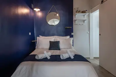 a bedroom with a large bed with blue walls at Papa Riviera - Nice old town - 1-3 pers in Nice
