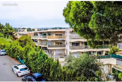 an apartment building with cars parked in a parking lot at Studio Jardin Fleuris Parking in Nice
