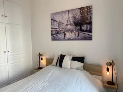 a bedroom with a bed and a painting on the wall at Chic and Cosy apartment GV Port Garibaldi in Nice