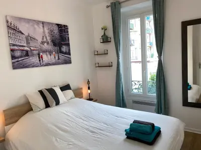 a bedroom with a white bed with a green suitcase on it at Chic and Cosy apartment GV Port Garibaldi in Nice