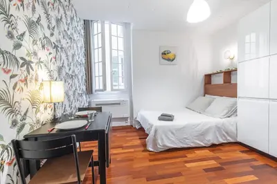 a bedroom with a bed and a desk and a table at Studio en plein cœur de la vieille ville à Nice in Nice