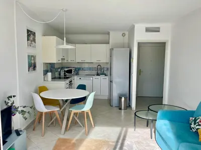a kitchen and living room with a table and chairs at Risso - charming one bedroom with a balcony in Nice