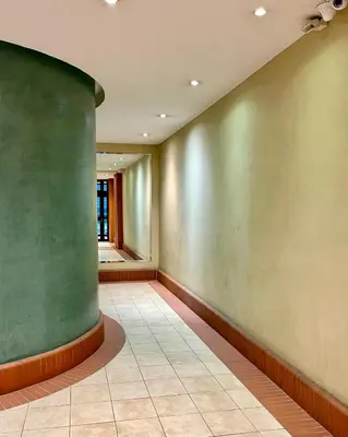 a hallway with a green wall and a tile floor at Risso - charming one bedroom with a balcony in Nice