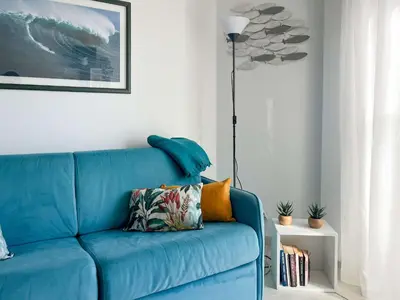 a blue couch in a living room with a lamp at Risso - charming one bedroom with a balcony in Nice