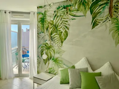 a bedroom with a mural of plants on the wall at Risso - charming one bedroom with a balcony in Nice