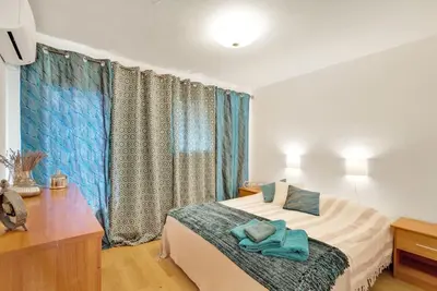a bedroom with a bed with blue towels on it at La Prom - a two bedroom apartment with a sea view in Nice