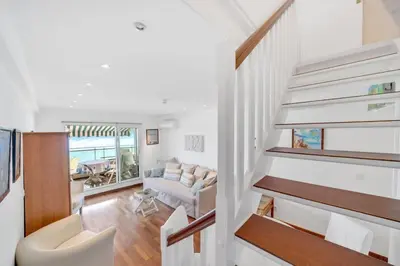 a staircase in a living room with a couch at La Prom - a two bedroom apartment with a sea view in Nice