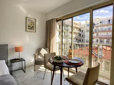 a living room with a table and a large window at Nestor&Jeeves - BERLIOZ SUITE - Downtown - Close beaches in Nice