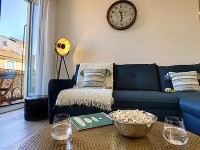 a living room with a blue couch and a clock at Nestor&Jeeves - MASSENA DREAM - Hyper center - Close sea in Nice