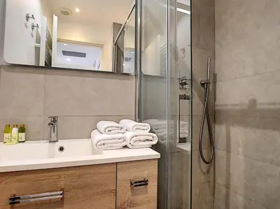 a bathroom with a sink and a shower with towels at Nestor&Jeeves - MASSENA DREAM - Hyper center - Close sea in Nice