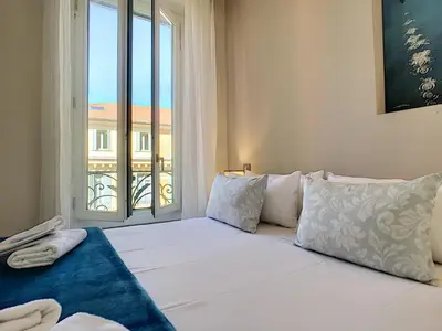 a bedroom with a large bed with a window at Nestor&Jeeves - MASSENA DREAM - Hyper center - Close sea in Nice
