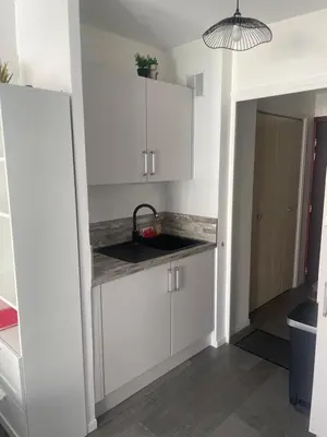 a kitchen with white cabinets and a sink at STUDIO ORANGERS in Nice