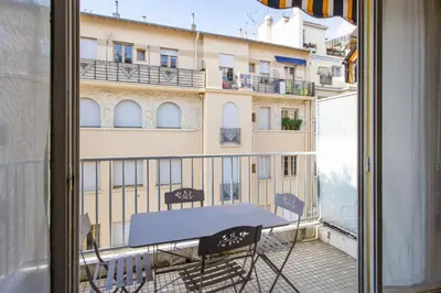 a table on a balcony with a view of a building at Le Refuge Acajou - Welkeys in Nice