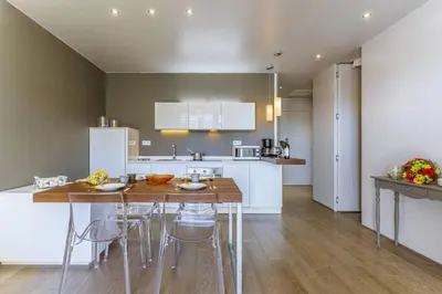 a kitchen with a table and chairs in a room at MY CASA - FLEURS 22 - City Center - Modern w Terrace in Nice