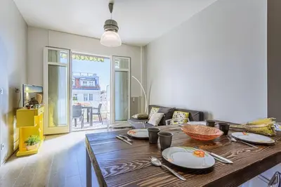 a living room with a wooden table with plates on it at MY CASA - FLEURS 22 - City Center - Modern w Terrace in Nice