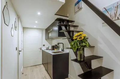 a kitchen with a staircase and a vase of flowers at MY CASA - BUNICO 1 - Old Town Renovated Studio in Nice