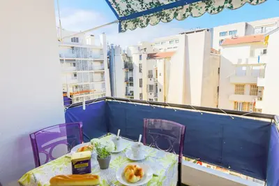 a table with a plate of food on a balcony at MASSENET PIETONNE AP4196 by Riviera Holiday Homes in Nice
