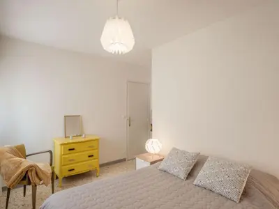 a bedroom with a bed and a yellow dresser at Apartment L'Amiral-1 by Interhome in Cagnes-sur-Mer
