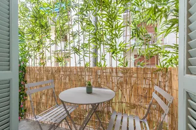 a table and chairs on a patio with a fence at HEROLD Balcon in Nice