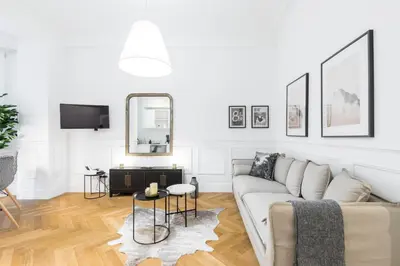 a white living room with a couch and a mirror at HEROLD Balcon in Nice