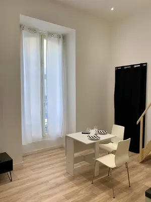 a white room with a table and two chairs at Gustave 2 in Nice