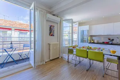a kitchen with a table and green chairs in a room at MY CASA - BERLIOZ 1 - City Center 2 rooms - Balcony in Nice