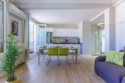 a kitchen and living room with a table and chairs at MY CASA - BERLIOZ 1 - City Center 2 rooms - Balcony in Nice