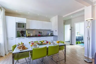a kitchen with a dining table and green chairs at MY CASA - BERLIOZ 1 - City Center 2 rooms - Balcony in Nice
