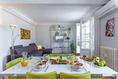 a living room with a table and green chairs at MY CASA - BERLIOZ 1 - City Center 2 rooms - Balcony in Nice