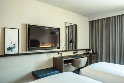a living room with a couch and a book shelf at Crowne Plaza - Nice - Grand Arenas by IHG in Nice