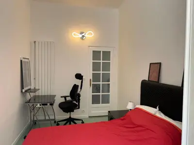 a bedroom with a red bed and a desk at Appart hyper centre Nice in Nice