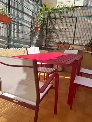 a red picnic table and chair on a patio at Appart hyper centre Nice in Nice