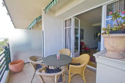 a patio with a table and chairs on a balcony at BEACHSIDE SUITE PANORAMIC - PROMENADE HOLIDAY in Nice