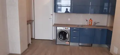 a washing machine in a kitchen with blue cabinets at Large beautiful studio near the NEGRESCO HOTEL in Nice