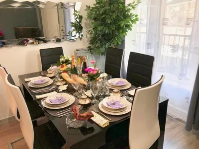 a dining room table with plates and dishes on it at Beau 3 pièces, 7 pers, 2 terrasses, centre, calme, sécurité in Nice