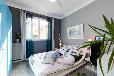 a bedroom with blue walls and a bed with pillows at Beau 3 pièces, 7 pers, 2 terrasses, centre, calme, sécurité in Nice