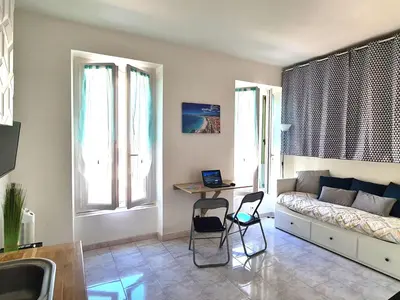 a living room with a couch and a table and chairs at NICE - Studio cosy hypercentre à 500m de la plage in Nice