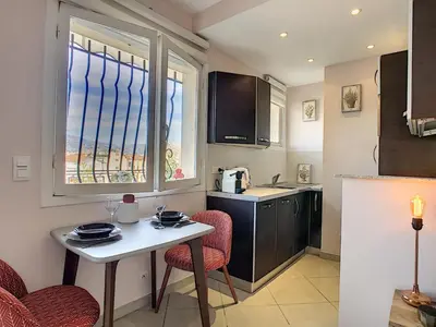 a small kitchen with a table and chairs and a window at Nestor&Jeeves - CORAL SEA TERRACE - Central - Very close beaches in Nice