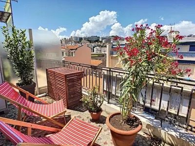 a balcony with two chairs and potted plants on a building at Nestor&Jeeves - CORAL SEA TERRACE - Central - Very close beaches in Nice