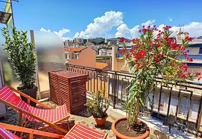 a balcony with two chairs and flowers on a balcony at Nestor&Jeeves - CORAL SEA TERRACE - Central - Very close beaches in Nice
