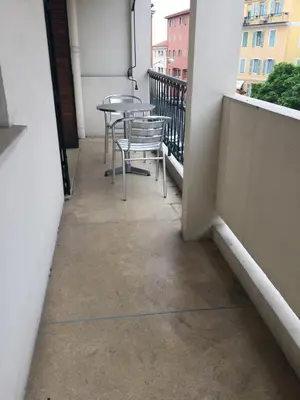 a balcony with tables and chairs on a building at Appartement T3 Climatisé entre mer et centre Nice in Nice