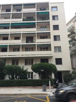 a car driving past a tall white building at Appartement T3 Climatisé entre mer et centre Nice in Nice
