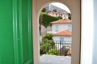 a green door with a view of buildings at Les Lauriers in Villefranche-sur-Mer