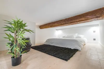 a bedroom with a bed and two potted plants at Studio Duplex - Vieux Nice - 100m de la mer in Nice